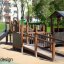 Gamma playground equipment with slide and climbing structures in a park setting