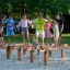 Children balancing and playing on Hip Hop wooden playground equipment outdoors.