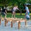 Children playing on Hip Hop wooden balance beams at a playground