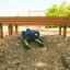 Person crawling under a wooden Hip Hop obstacle course on a playground.