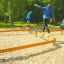 People balancing on wooden beams in an outdoor gym using the Balance product.
