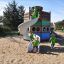 Children playing on Majestic ship with slide in a sandy playground.