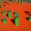 Green Jumping pegs (5 pcs.) on an orange playground.