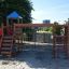 Children's playground with a climbing net, a slide and a set of ladders.