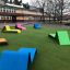 Colorful outdoor Lounge chair set on green lawn in front of a building.