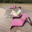 Man sitting on an outdoor pink Lounge chair on a sunny day.