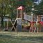 Playground equipment Twister castle with slide with climbing wall and swings in a park.