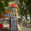 Twister castle with slide in a park surrounded by trees.