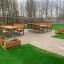 Outdoor Kyoto Table and benches set on a patio with green grass.