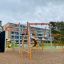 Sirius steel structure playground equipment with orange and gray bars in a schoolyard.