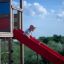 Child sliding down a red slide from Searobber Castle.