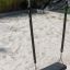 Single Swing hanging on chains above a sandy playground.