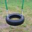 Double Swing with black tire seat and grass background.