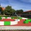 Modern outdoor Multiarena with basketball hoops and seating areas on a recreational court.