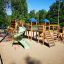 Outdoor playground equipment featuring a large wooden Space Station castle with slide.