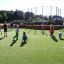 Children playing on Multiarena sports field on a sunny day.