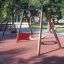 Rubber Tiles 55 under playground swings in a park setting.