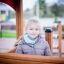 Little girl playing inside a Villa Maxi sandbox with a playhouse.
