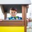 Child playing inside the Villa Maxi sandbox with a playhouse.