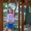 a girl playing on the playground climbing frames