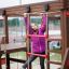 Girl playing on Chimpanzee wooden playhouse climbing ropes.