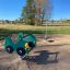 Double Auto rocking playground equipment on a sandy ground in an outdoor play area.