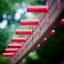 Activity Center wooden playhouse with red climbing handles for children.
