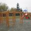 Activity Center wooden playhouse with climbing structures and slide in a playground