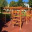 Activity Center wooden playhouse with climbing nets and ladders on a playground.