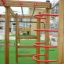 Wooden playhouse Activity Center with climbing structures and slides.