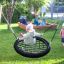 a child swinging on a bird nest swing in the kindergarten