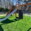 Playground equipment with slide and climbing net designed like a spider web, Spiderman theme.