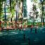 Wooden playground structure 'Course' in a forested area with green flooring.