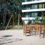 Obstacle Course wooden playground equipment with climbing and balancing features on sandy ground nea