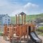 Rubik Modern Nature wooden playhouse with slide on sandy playground