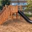Wooden playhouse with slide from Kiosk Modern Nature.