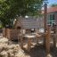 Wooden sandbox playhouse with tables and stools from the Veranda House Nature product line.