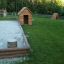 Wooden Small House in playground near sandbox area.