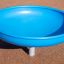 Blue Flying Saucer playground equipment on sandy surface.