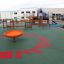 Orange Flying Saucer playground equipment on green surface with other play structures in the backgro