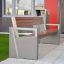 Modern outdoor Chicago Bench with concrete and wooden design near a building entrance.