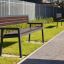 Oxford Bench in a park along a paved walkway.