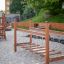 Chain Bridge wooden playground equipment with swing steps and climbing ladder in a sandy play area.