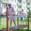 Children playing on Chain Bridge play structure in a park.