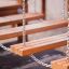 Wooden steps of Chain Bridge playground equipment suspended by metal chains