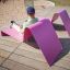 Man relaxing on pink Lounge Sofa on a wooden deck.