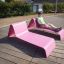 Man relaxing on a pink Lounge Sofa outdoors.