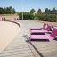 Pink Lounge Sofa chairs on a boardwalk by the beach.