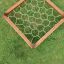 Aerial view of Honeycomb climbing net in wooden frame on grass.