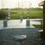 Outdoor solar-powered grill on gravel surface with green field background.